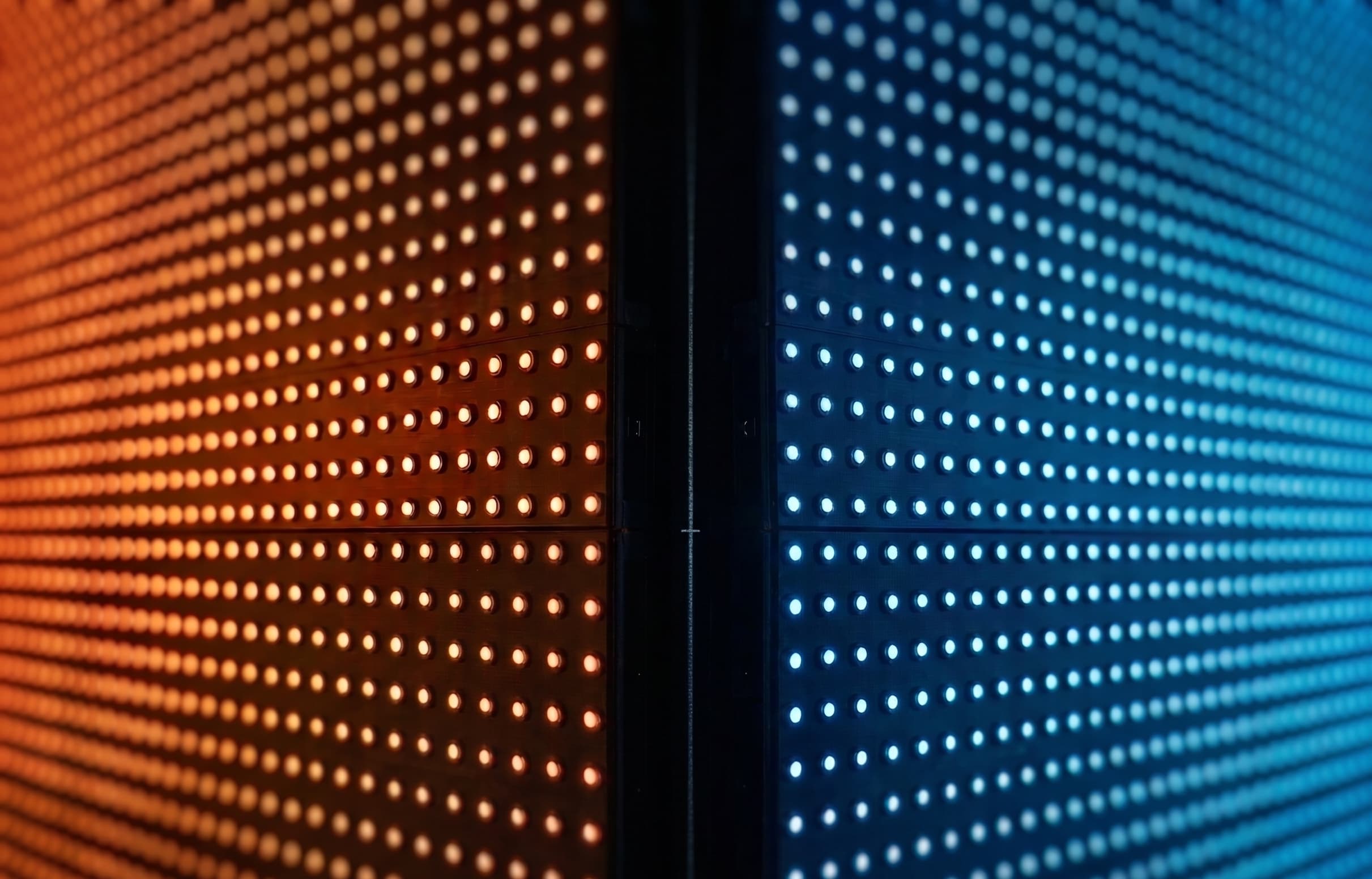 LED wall displaying abstract visuals in orange and blue hues.